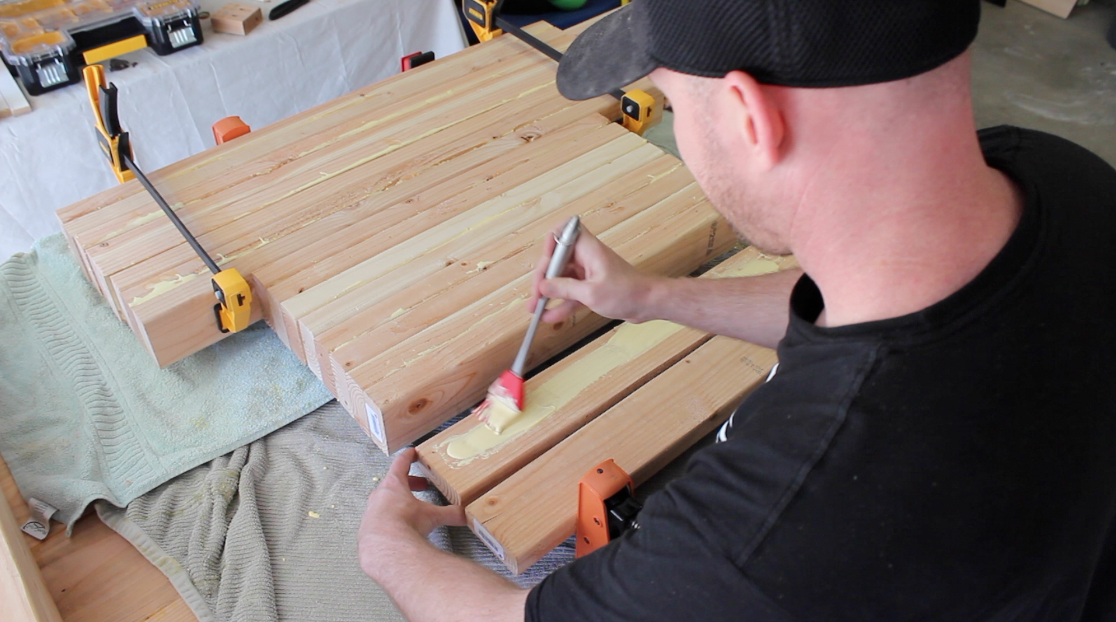 gluing together 2 by 4 boards for the table legs