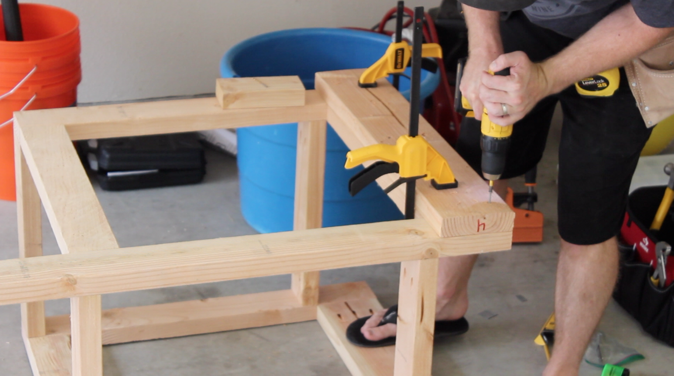 attaching 2 by 6 board to reinforce workbench leg