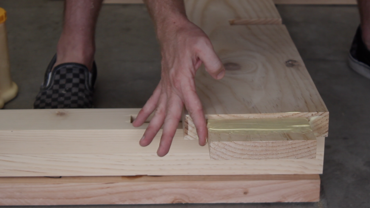 applying wood glue to through tenon on table stretcher