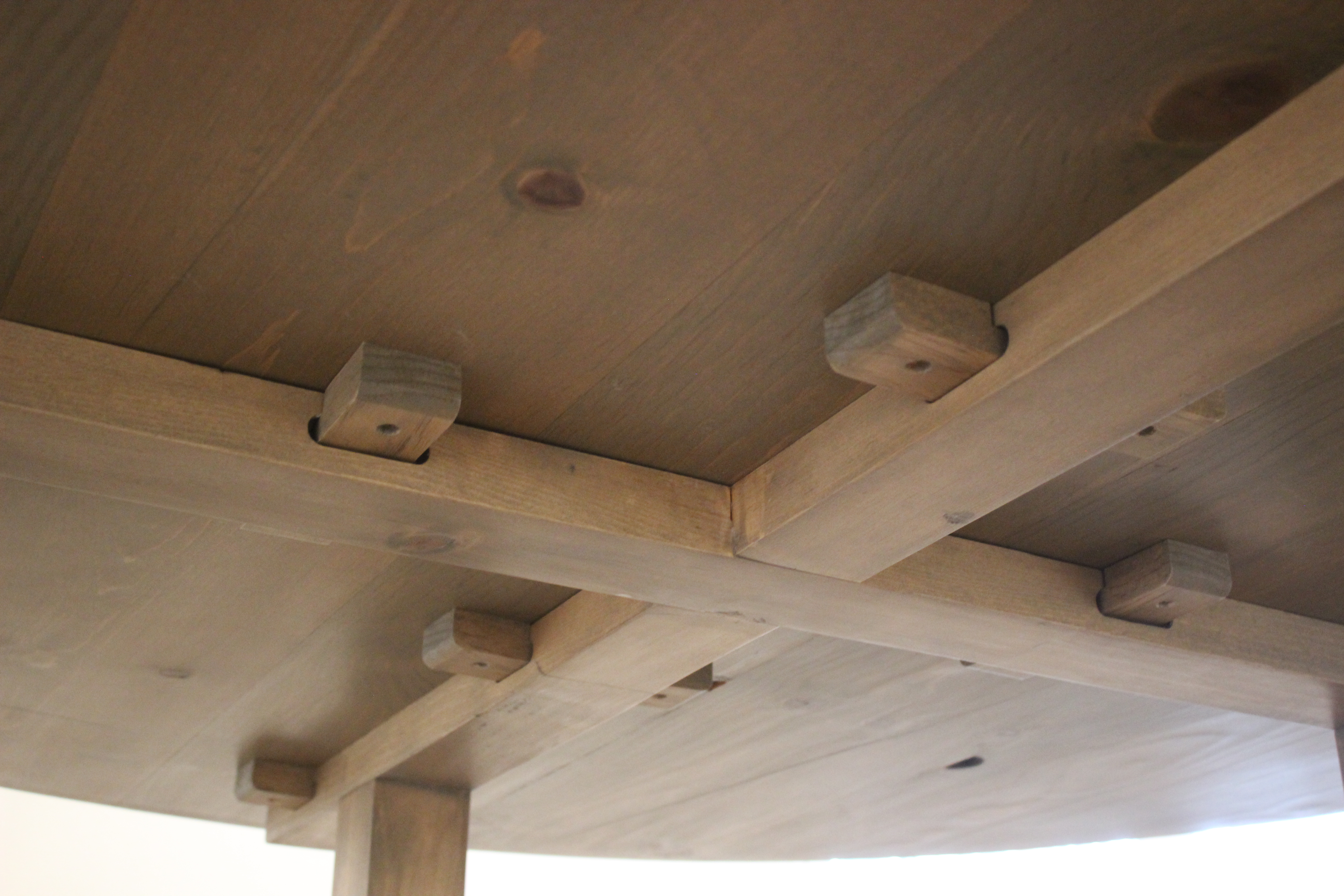 bottom view of table top with wooden fasteners holding it to the table frame